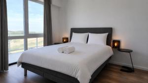 a bedroom with a large bed with two towels on it at Residentie De Zeester | De Schelp in Scherpenisse