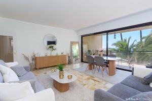 a living room with a couch and a table at Festival de Cannes résidence de luxe piscine tennis in Vallauris