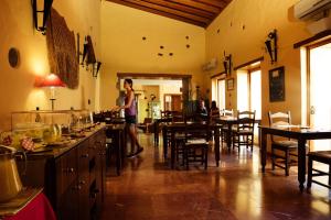 a woman standing at a counter in a restaurant at Hotel Rural Casa de Los Camellos in Agüimes