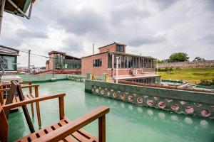 a river with a building and chairs in the water at Stay ongyeol in Suwon