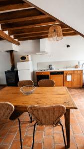 a kitchen with a wooden table and chairs at Gîte du Noyer in Villexanton