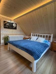 a bed in a room with a wooden ceiling at Koronkowa Chatka w Beskidach in Istebna