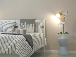 - une chambre avec un lit et un vase avec une plante dans l'établissement 8 Colonne Apartments, à Bologne