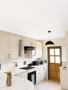 a kitchen with white cabinets and a stove top oven at High tide complex in Langstrand