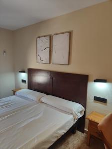 a bedroom with a bed with two pictures on the wall at Hotel La Jara-Arribes in Aldeadávila de la Ribera