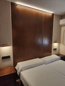 a bedroom with a bed and a wooden headboard at Hotel La Jara-Arribes in Aldeadávila de la Ribera +11 photos