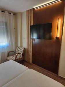 a hotel room with a bed and a flat screen tv at Hotel La Jara-Arribes in Aldeadávila de la Ribera