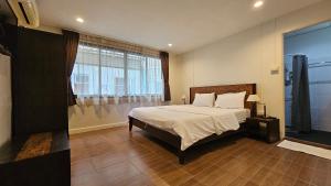 a bedroom with a large bed and a large window at Baan Glang Soi Restaurant & Guesthouse in Bangkok
