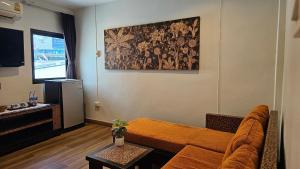 a living room with a couch and a television at Baan Glang Soi Restaurant & Guesthouse in Bangkok