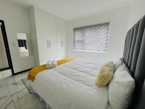 a bedroom with a large white bed and a window at Lady Victoria in Walvis Bay