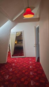 an empty hallway with a red carpet and a red light at zeer ruim appartement in Zottegem