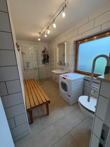 a bathroom with a washing machine and a washer and dryer at Tischlerei in Barum +5 photos