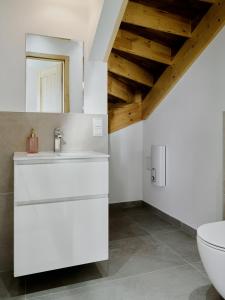 a white bathroom with a sink and a toilet at Domki Różane Nad Stawem in Stopnica