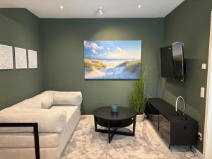 a living room with a couch and a table at Ostwall Terrassen Apartment in Bocholt