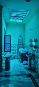 a room with two beds and a blue light at Gyan Nivas in Bareilly