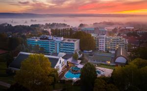 a view of a city in the fog at sunset at Hotel Carbona Thermal Spa in Hévíz