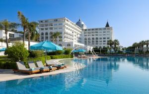 a large swimming pool with chairs and a hotel at Nirvana Dolce Vita - Ultra All Inclusive in Tekirova