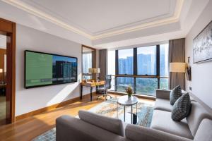 a living room with a couch and a flat screen tv at 杭州钱江新城黄龙璀怡酒店 凯悦尚选 in Hangzhou