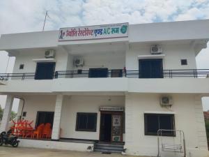 a white building with a sign on top of it at Jyoti Hotel and Restaurant in Desuri