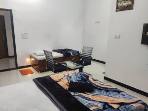 a room with two beds and chairs in it at Jyoti Hotel and Restaurant in Desuri