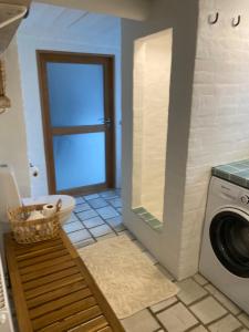 a bathroom with a washing machine and a washer at Byhus Bogense in Bogense