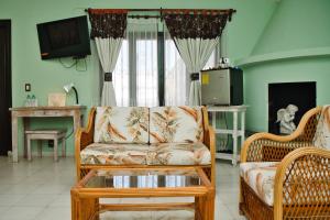 a living room with a couch and a tv at Villa Bonita Les Terrasses in Cuernavaca
