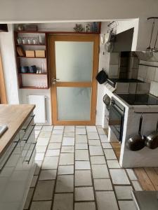 a kitchen with a door and a tiled floor at Byhus Bogense in Bogense