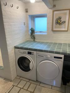 a laundry room with a washing machine and a window at Byhus Bogense in Bogense