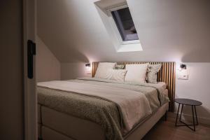 a bedroom with a large bed with a skylight at De Viervoeters Hoeve in Ruiselede