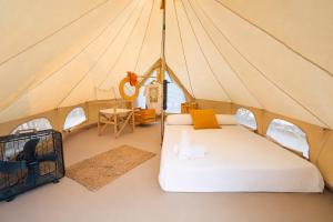 a bedroom in a tent with a bed and a desk at Kampaoh Oliva in Oliva