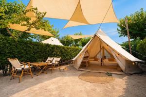 a tent with chairs and a table and a table and umbrella at Kampaoh Oliva in Oliva