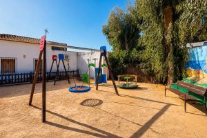 a playground with several swings in a yard at Kampaoh Oliva in Oliva