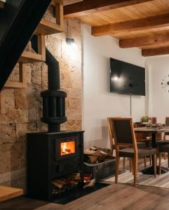 a fireplace in a living room with a table at Brvnara K2 KONAK in Šljivovica