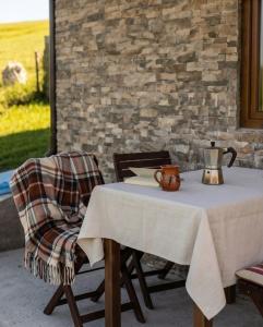 a table and a chair with a pitcher on it at Brvnara K2 KONAK in Šljivovica