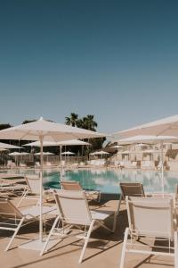a group of chairs and umbrellas next to a swimming pool at Tursport in Taranto