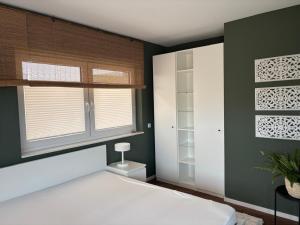 a bedroom with a white bed and a window at Ostwall Terrassen Apartment in Bocholt