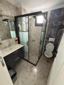 a bathroom with a shower and a toilet and a sink at Atlas Suite Trabzon in Trabzon +12 photos