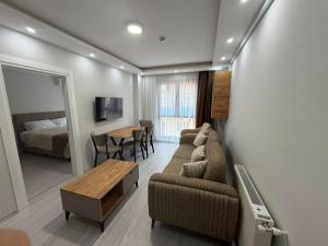 a living room with a couch and a table and a bed at Atlas Suite Trabzon in Trabzon