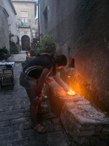a woman is lighting a fire in a brick oven at TRE METR SOPRA IL CIELO ''AcquAria'' in Felitto