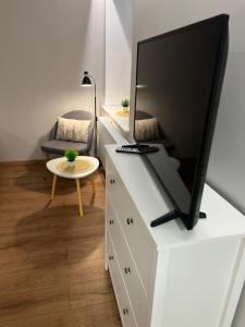 a living room with a tv on a dresser at Apartament Rynek 17 in Krosno