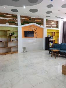 a living room with a couch and a tv on a wall at QN Home in Quy Nhon