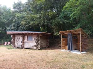 a log cabin with a shed in a field at Le nid de bois insolite in Haget