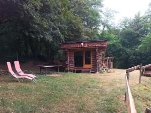 a log cabin with a picnic table and a bench at Le nid de bois insolite in Haget