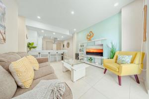 a living room with a couch and a tv at Aracari Residences by Bocobay - Luxury Condos 5 min Walk to Ritz and Palm Beach in Palm-Eagle Beach +34 photos