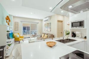 a kitchen with a counter top and a living room at Aracari Residences by Bocobay - Luxury Condos 5 min Walk to Ritz and Palm Beach in Palm-Eagle Beach