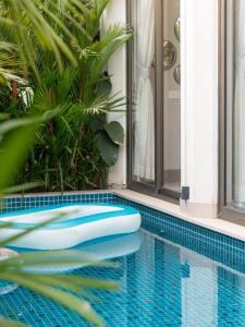 a swimming pool with a tub in the middle of a house at The Ten in Siolim +58 photos