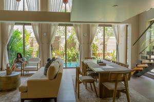a woman sitting on a couch in a living room at The Ten in Siolim