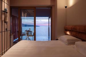 a bedroom with a bed and a view of the water at Laqua by the Sea in Meta +31 photos