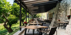 una fila de mesas y sillas en un patio en Domaine de Châteauvieux, en Peney-Dessus