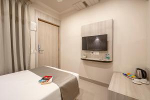 ein Hotelzimmer mit Bett und Flachbildfernseher in der Unterkunft Anthurium Hotel in Mapusa + 4 Fotos